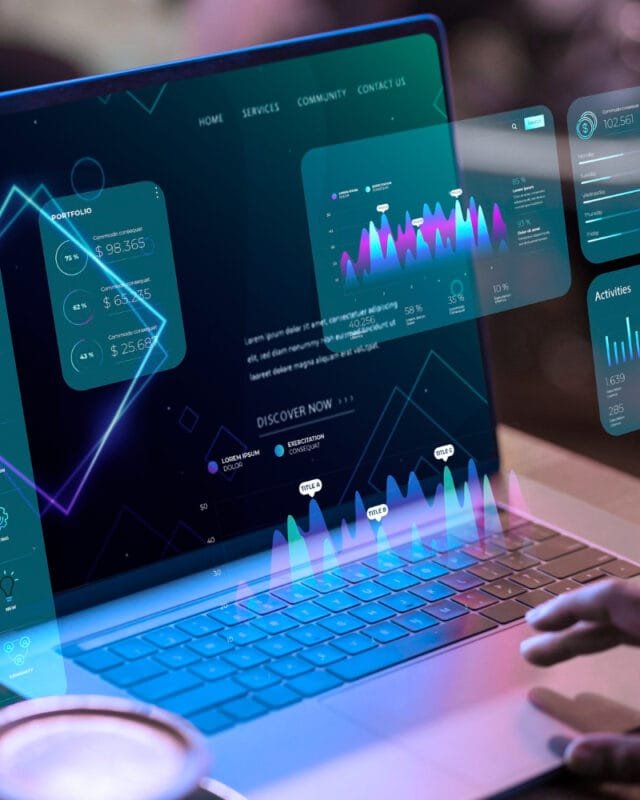 A user interacts with a laptop displaying a futuristic dashboard to symbolise Asia M&A Digital Disruption, featuring data visualizations and portfolio statistics.