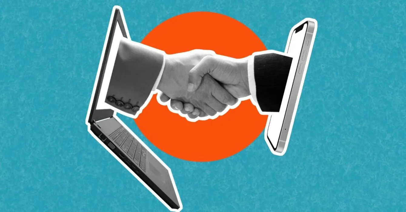 7774 A handshake emerges between a laptop and a smartphone, symbolizing digital connection and collaboration against a vibrant blue background.