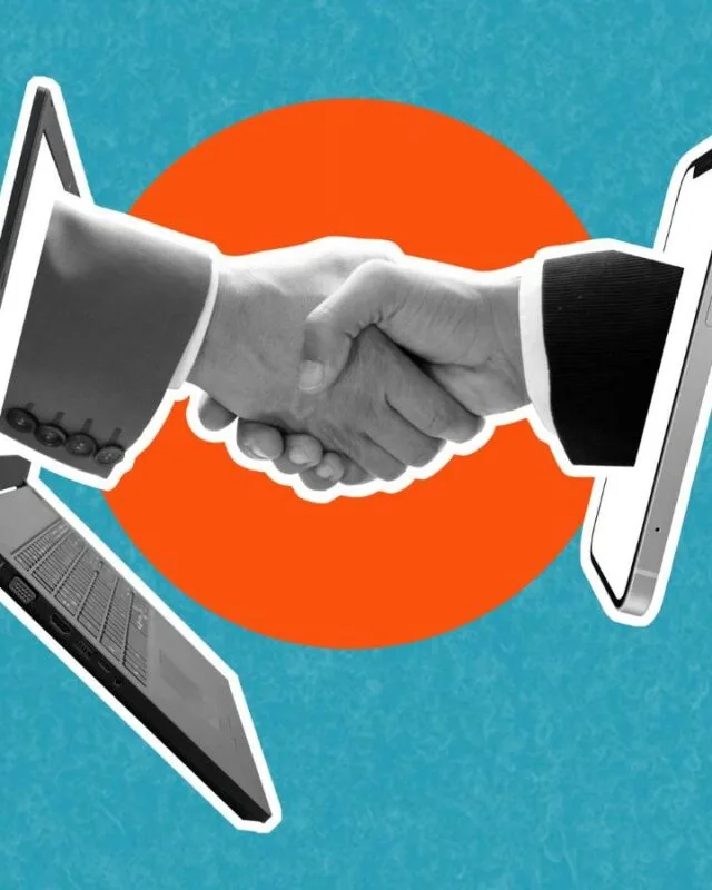 7774 A handshake emerges between a laptop and a smartphone, symbolizing digital connection and collaboration against a vibrant blue background.