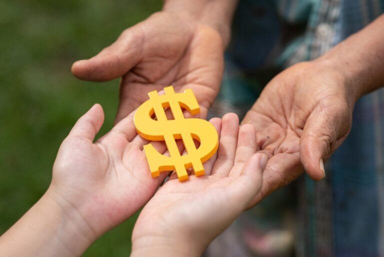 Asia Infrastructure M&A Fundraising: A child's hands receive a yellow dollar sign from an older adult's hands, symbolizing a transfer of wealth and support.